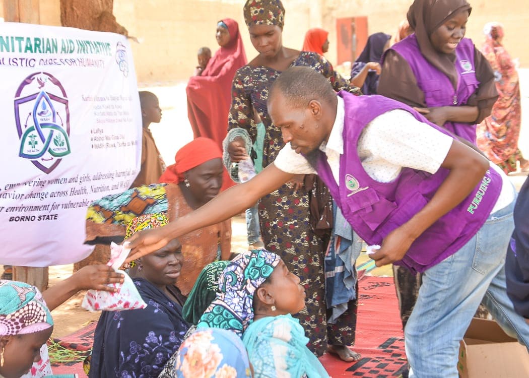 HHAI staff distributing food supplies to women in an IDP community, Borno State