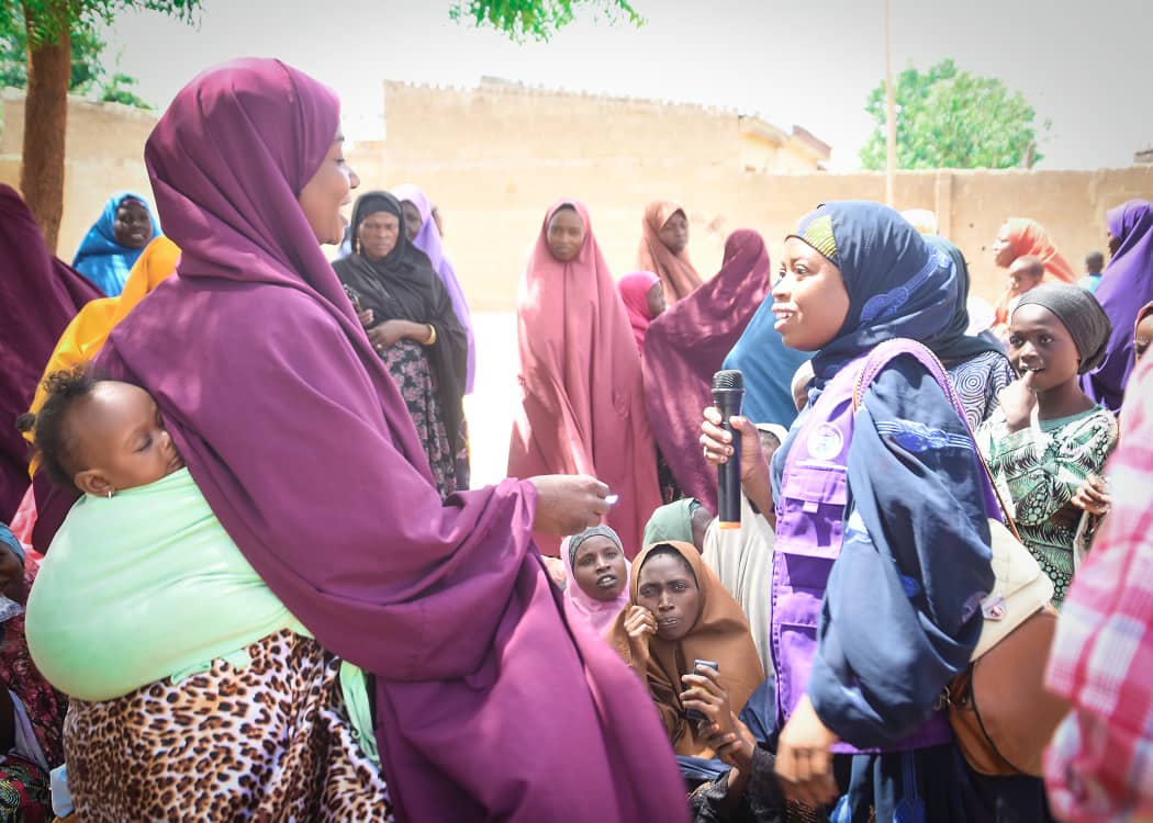 HHAI health worker speaking with a mother and her baby during community outreach